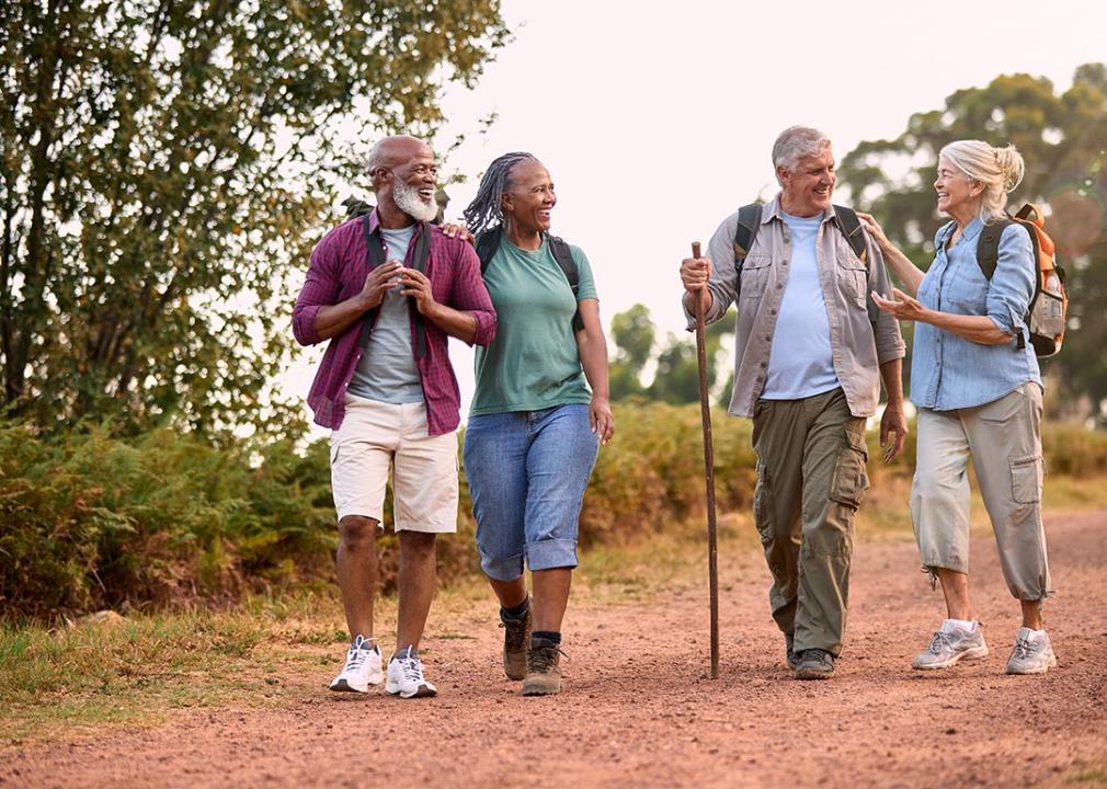 group of four seniors walking in the countryside