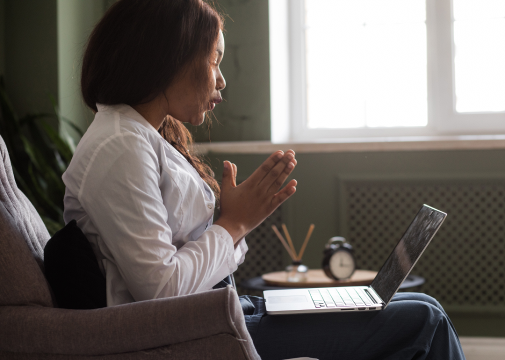 woman sitting on couch in session facing laptop 