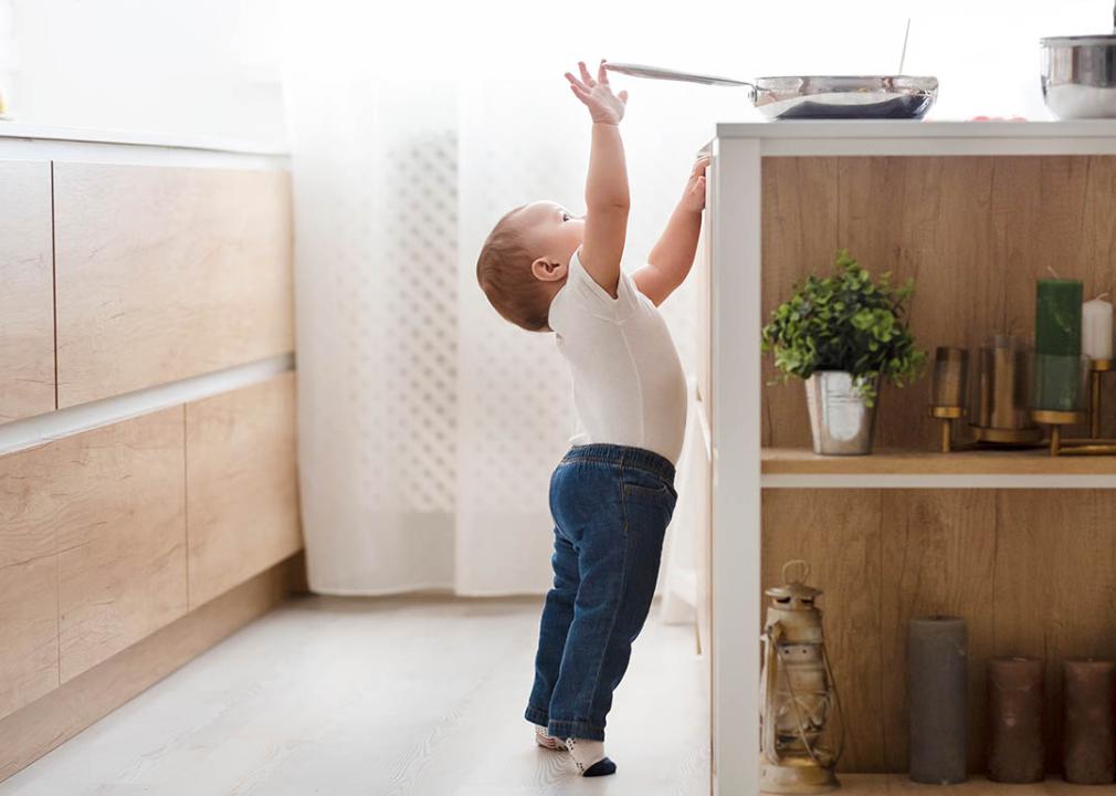 child reaching for stove