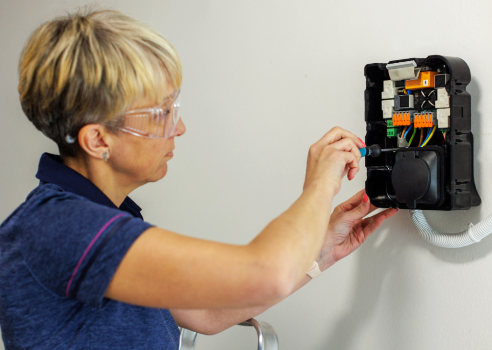 woman installing EV charger at home
