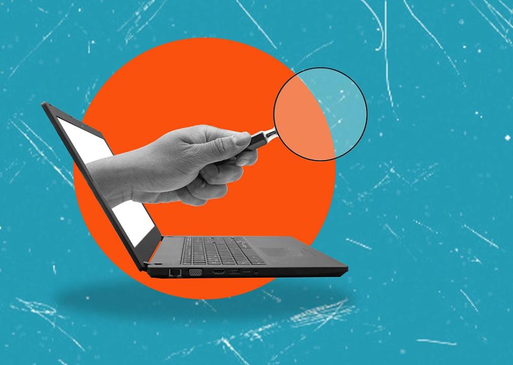 concept of background check illustrated with hand holding magnifying glass coming out of computer screen