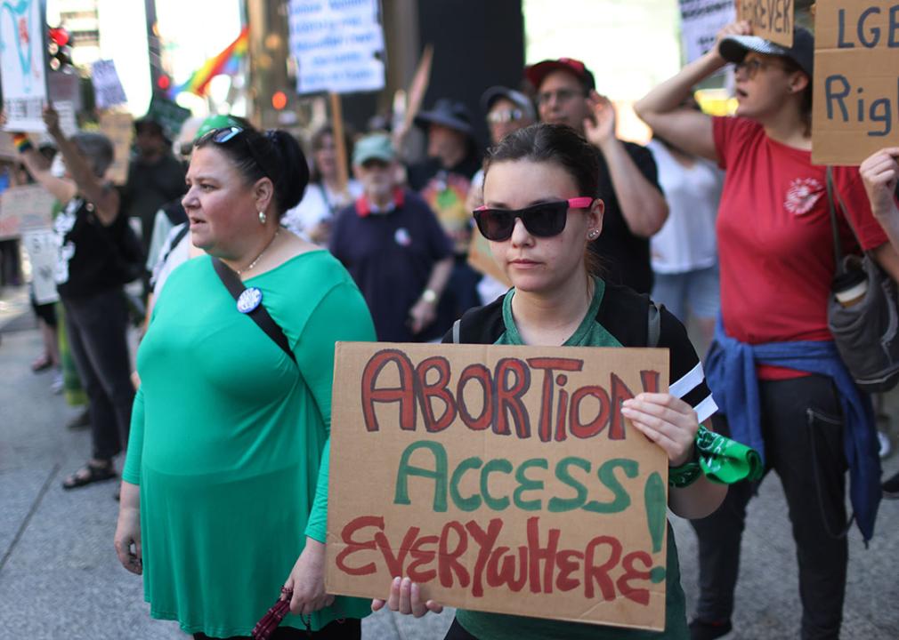 Demonstrator holds a cardboard sign that says "Abortion Access Everywhere" standing with activists for a rally at the Federal Building Plaza in Chicago, Illinois. 