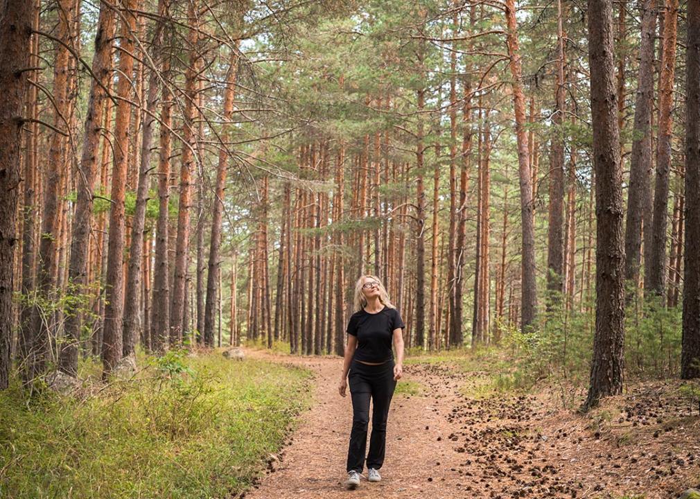 Woman connecting with nature, forest bathing. 