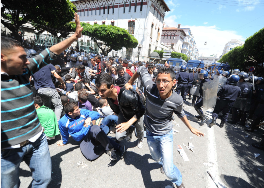 Protestors run with some who have fallen to the ground.