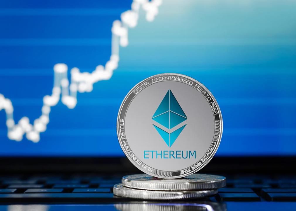 Silver ethereum coin with conceptual finance chart in background.