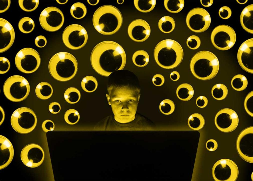 Photo illustration of student at laptop surrounded by many pairs of googly eyes watching; surveillance concept.