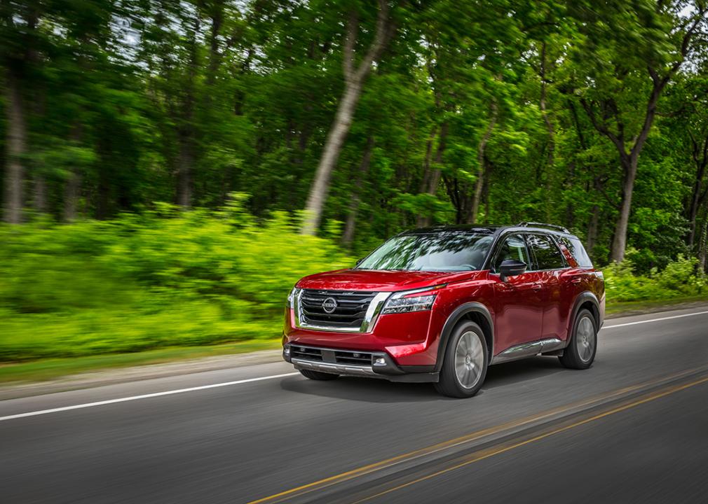 A red 2023 Nissan Pathfinder driven on the road.