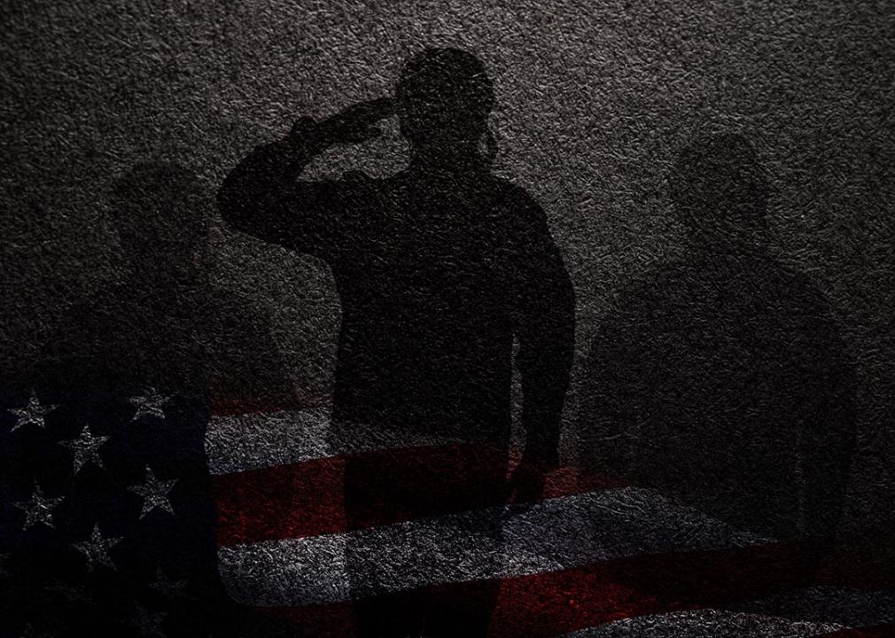 Concept of military sexual assault illustrated by three silhouettes against a dark wall, faint overlay of American flag beneath.
