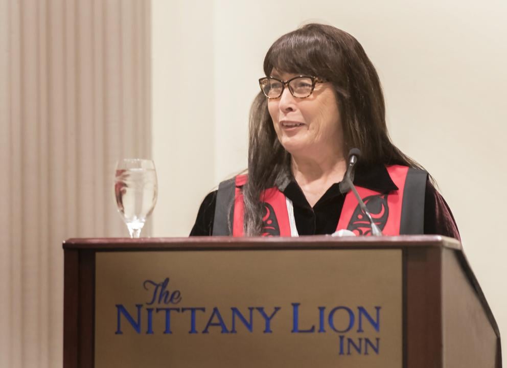 Charlene Teters speaking behind a podium at the Penn State Forum in 2018, held at the Nittany Lion Inn on the University Park campus.