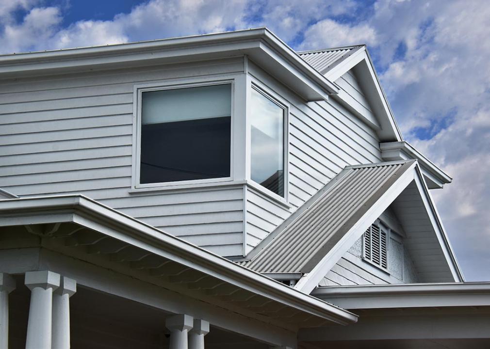 House with angled roofs that use white corrugated metal. 