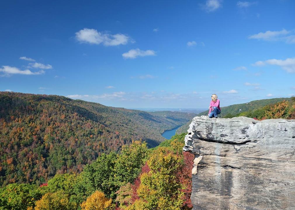 Scenic view of person in a pink shirt sitting on the Coopers Rock outlook in West Virginia.