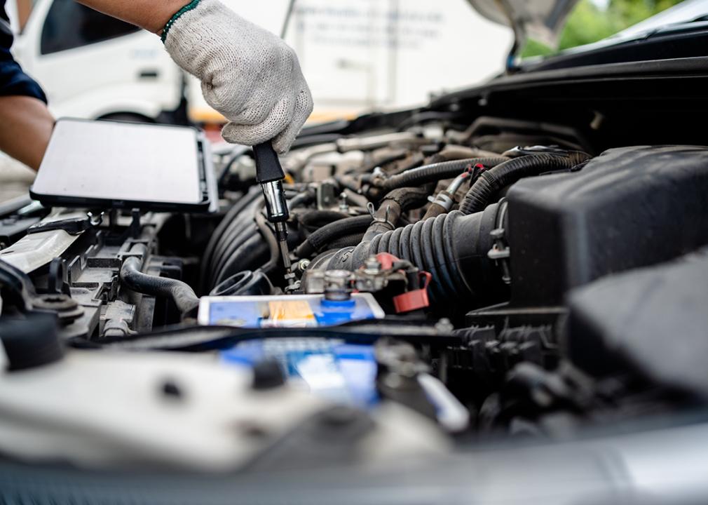 A mechanic performing repairs and maintenance on a car.