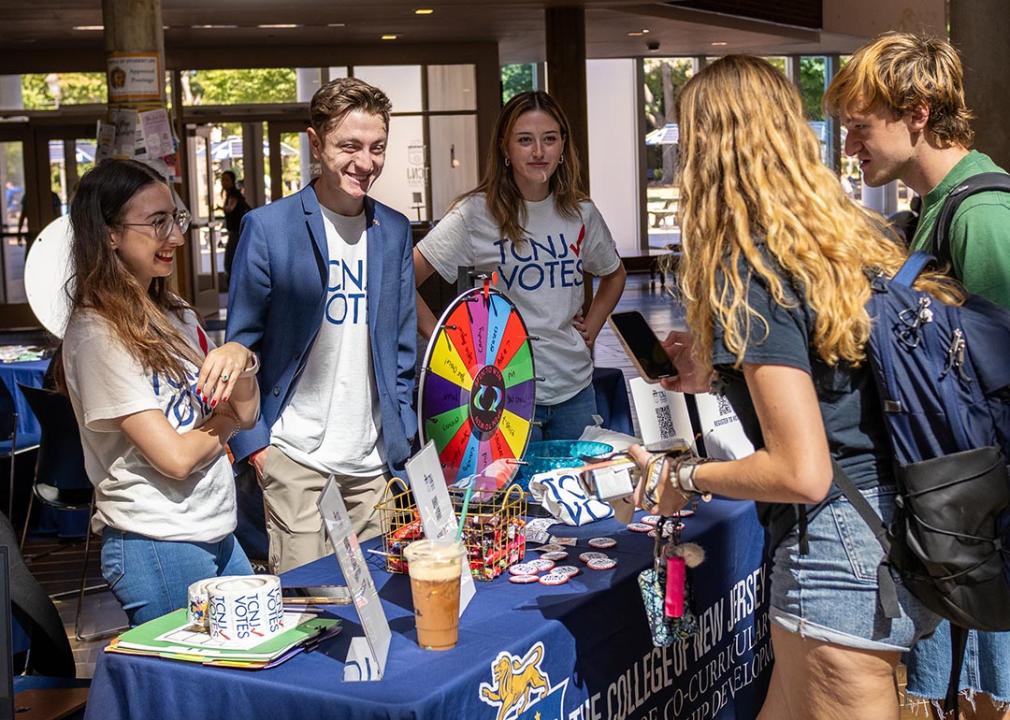 Students help staff the voter registration table in the student center of The College of New Jersey.