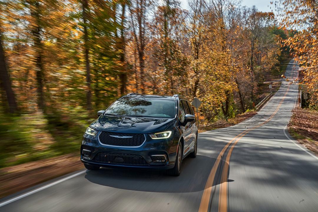 A black 2025 Chrysler Pacifica Hybrid on the road.