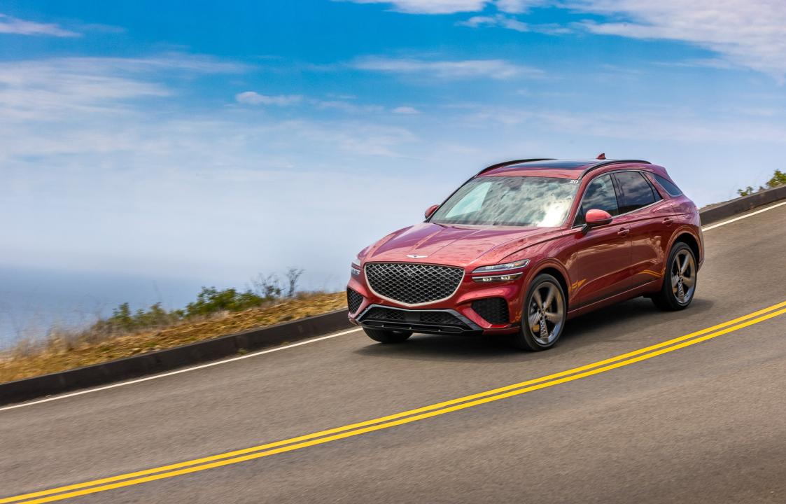 A red 2025 Genesis GV70 on the road.