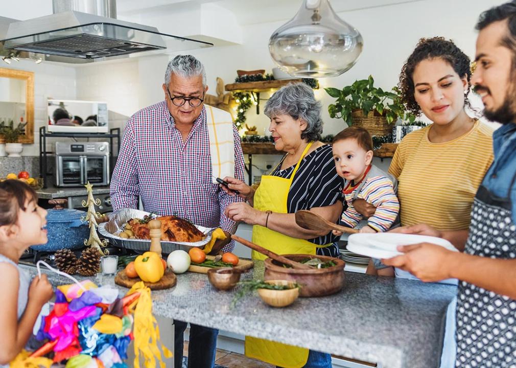 Multiple generations of a Latine family cooking together in the kitchen for the holidays.