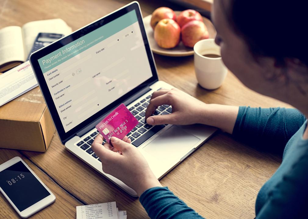 A woman using her credit card to pay for online shopping.