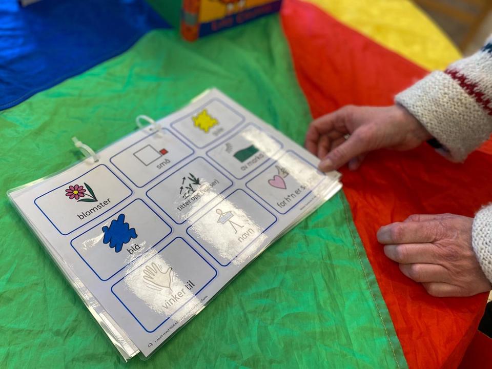 A teacher at a child care program run by Kanvas sets out a packet created to help children learning Norwegian communicate with staff members.