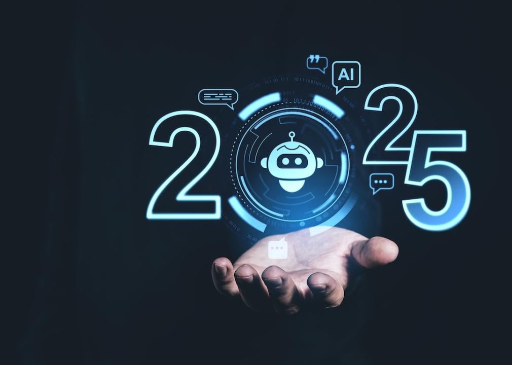 A person holding up a digital display showing AI trends for 2025.