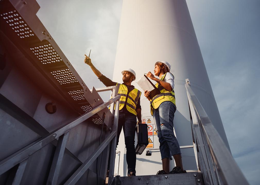 Two wind turbine technicians inspecting a site. 