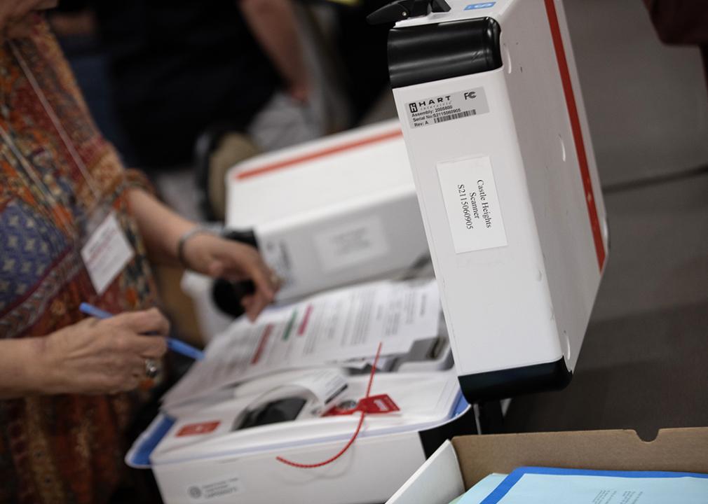 Poll workers return voting equipment to central county station workers.