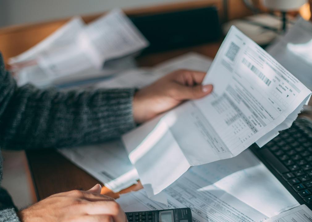 Person reading an electricity bill and calculating costs.