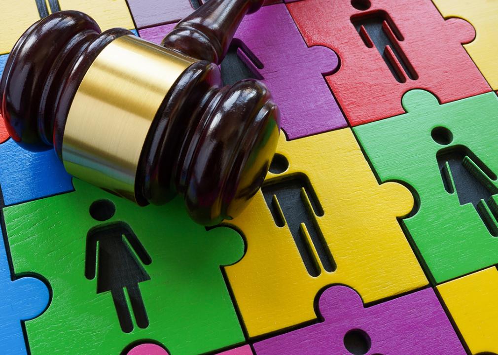 A gavel as a concept of law is over a puzzle of male and female figures as a concept of Alzheimer's.