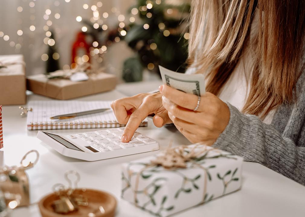 Woman organizing expenses with holiday purchases and ornaments still around her.