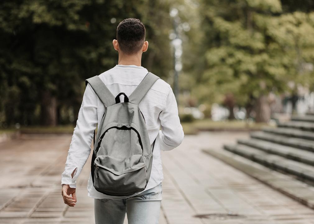 Photographed from behind, a young student walking in university.