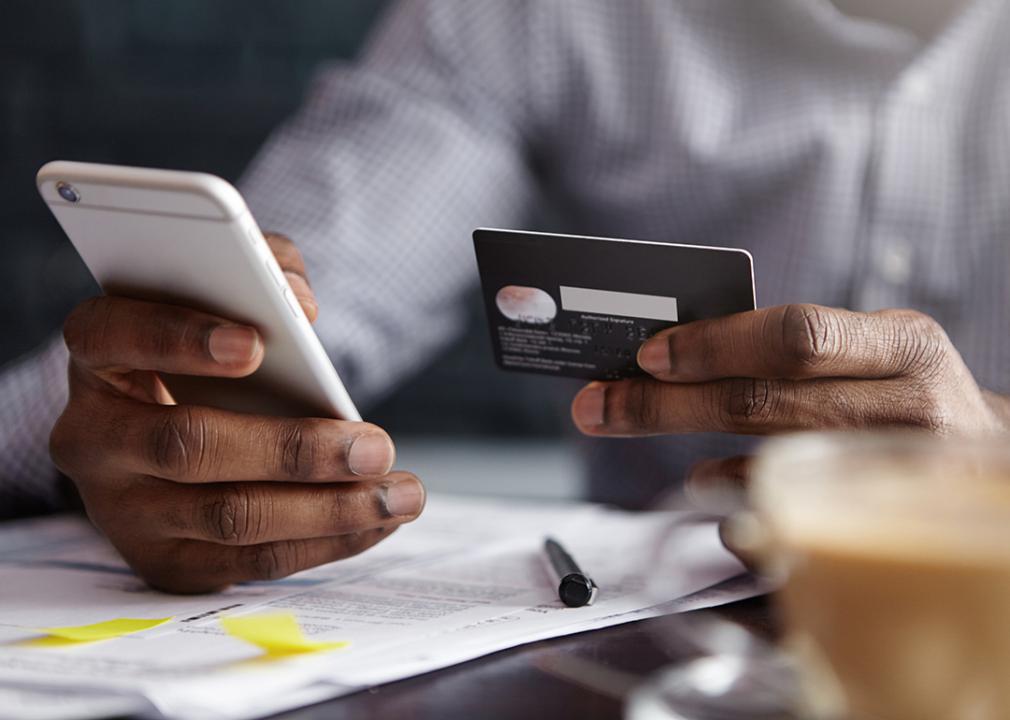 Businessman using a corporate card for a purchase using a mobile phone.