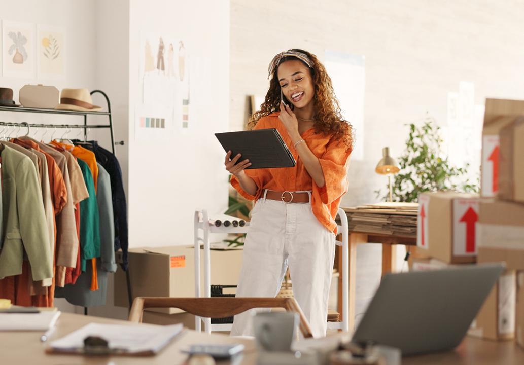 Small business owner talking on the phone and looking at business data.