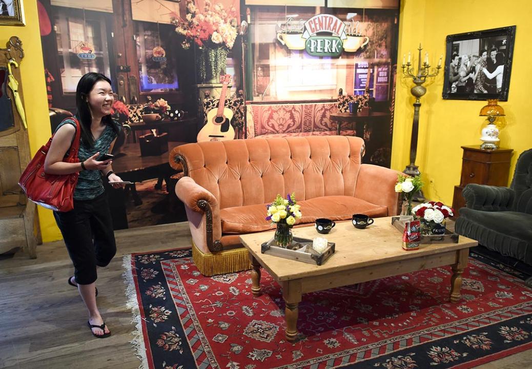 A woman walks inside a temporary pop-up reproduction of the "Central Perk" coffee shop, a center piece set of the television situation comedy "Friends."