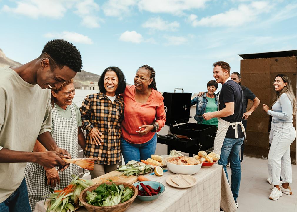 A multigenerational family bonds over food and happily engaging during a summer outdoor gathering.