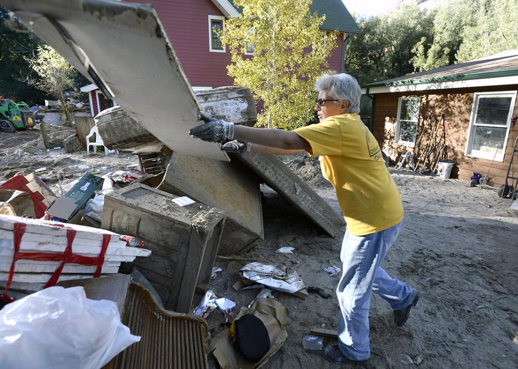 Barb Headrick throws damaged drywall into a pile while cleaning a flood damaged in Jamestown, Colorado on Sept. 28 2013.