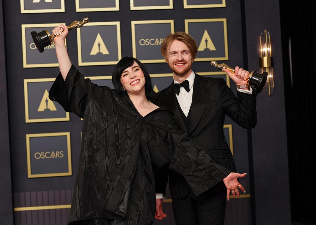 Billie Eilish and FINNEAS raising their Oscars statues in the press room during the 94th Annual Academy Awards at Hollywood and Highland on March 27, 2022 in Hollywood, California.