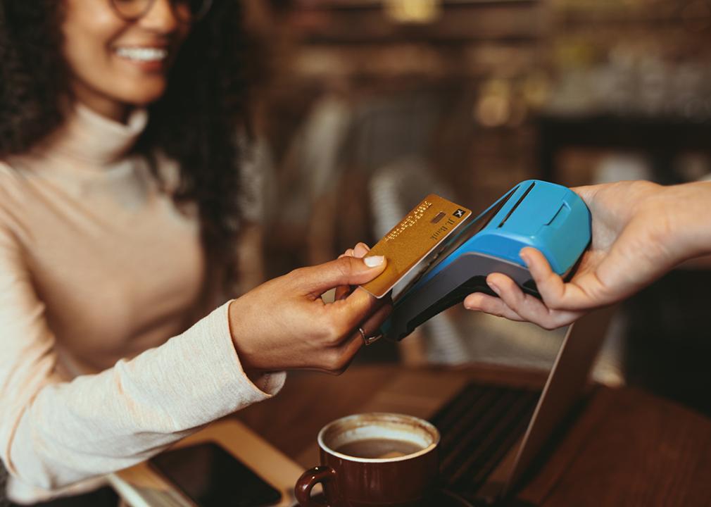 A woman taps her credit card in a restaurant