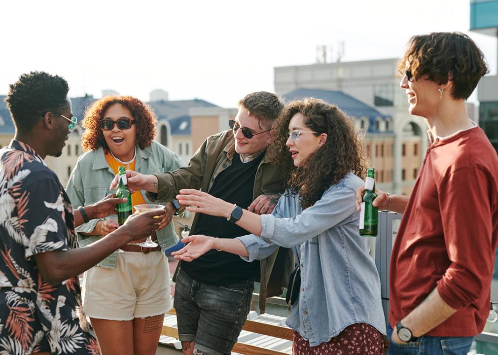 A group of young adults hanging out at a rooftop outdoor party.