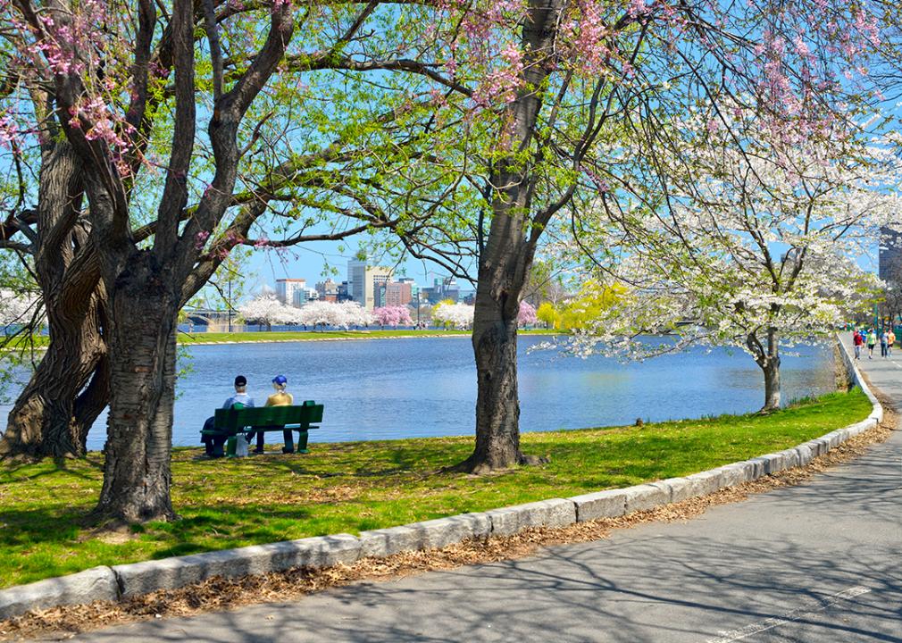 Two people sitting on a bench by the Charles Rives Esplanade in Boston, Massachusetts.