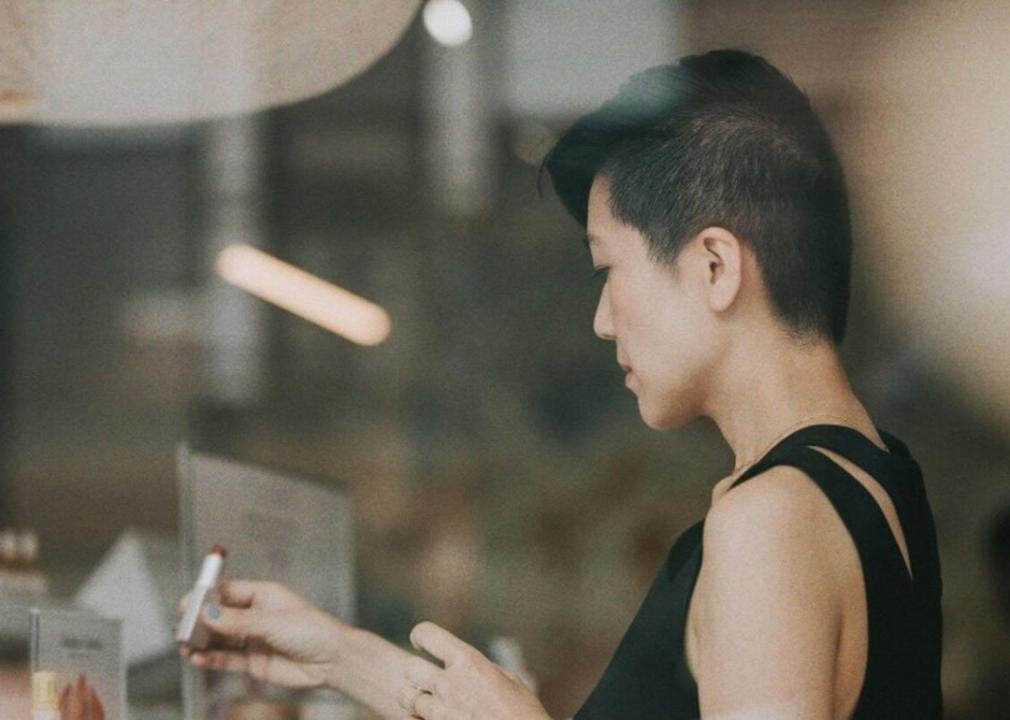 A woman trying out a lipstick in a store.