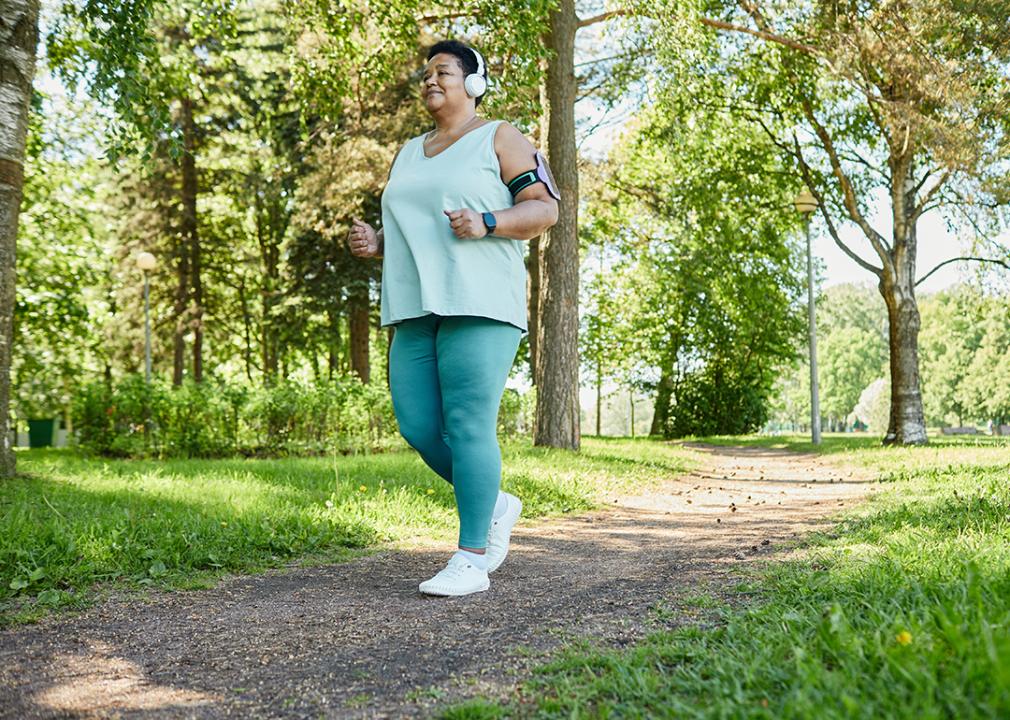 A senior black woman enjoying a morning run in a park.