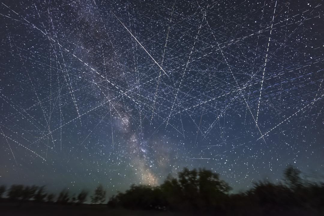 Long-exposure taken over 30 seconds showing many satellites moving across the night sky appearing as dotted lines.