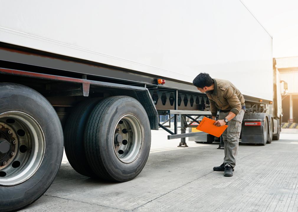 A mechanic inspecting a cargo truck for transport.