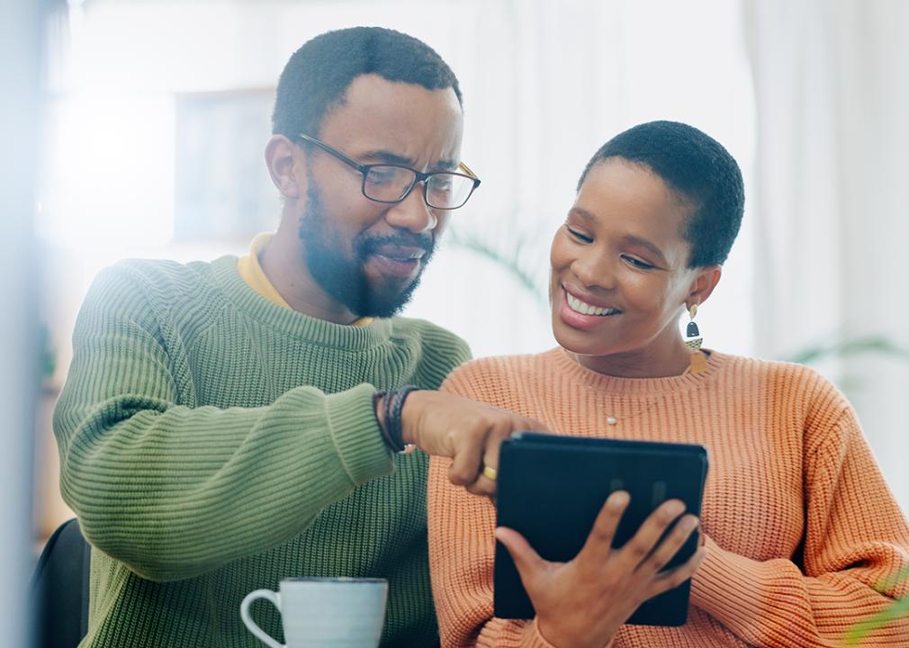 A black couple using a tablet at home to look up information.