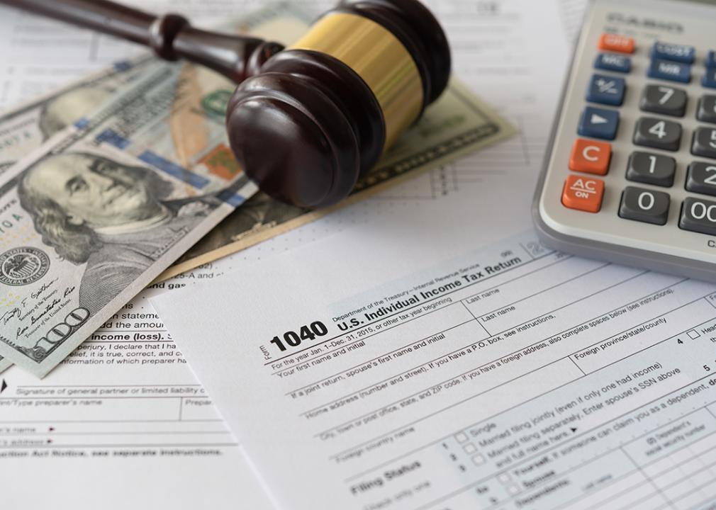 Tax law changes concept showing tax forms, bank notes, a calculator and a judge gavel.