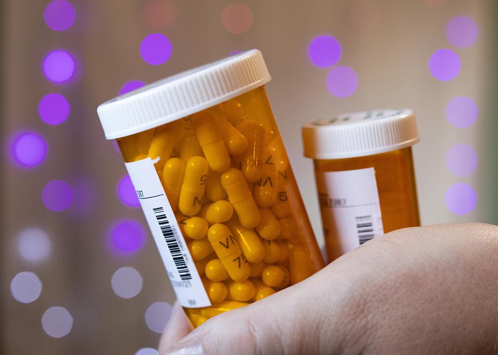 Person holding two bottles of prescription medicines.