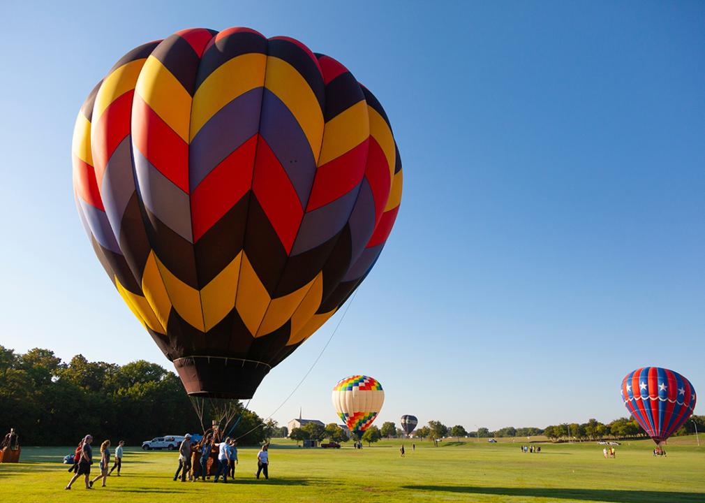 A colorful hot air balloon takes flight at a festival on a summer day in Plano, Texas.