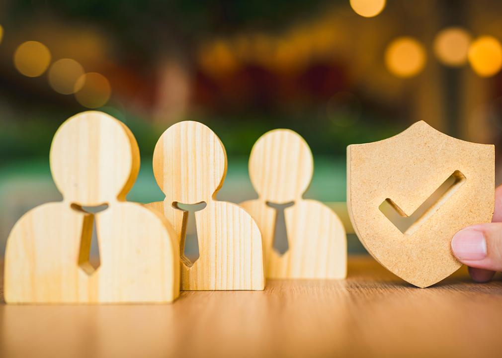 Wooden symbols for employees and a shield for insurance.