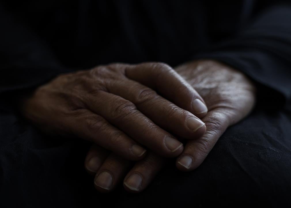 Hands of someone who is staying at a homeless shelter for domestic violence survivors, where funding cuts will impact services.
