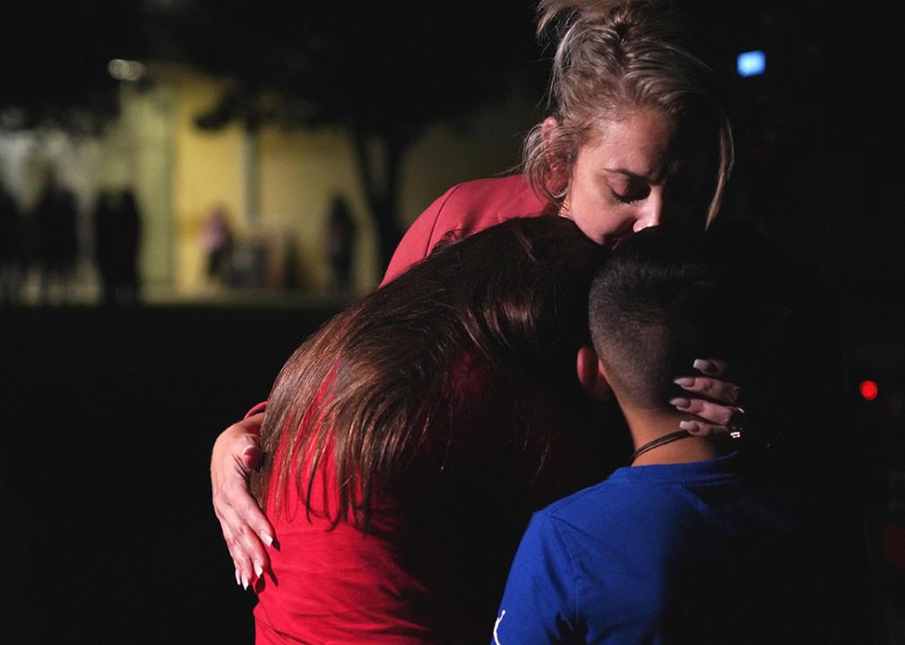 Families hug outside the Willie de Leon Civic Center where grief counseling is offered after a school shooting in Uvalde, Texas.