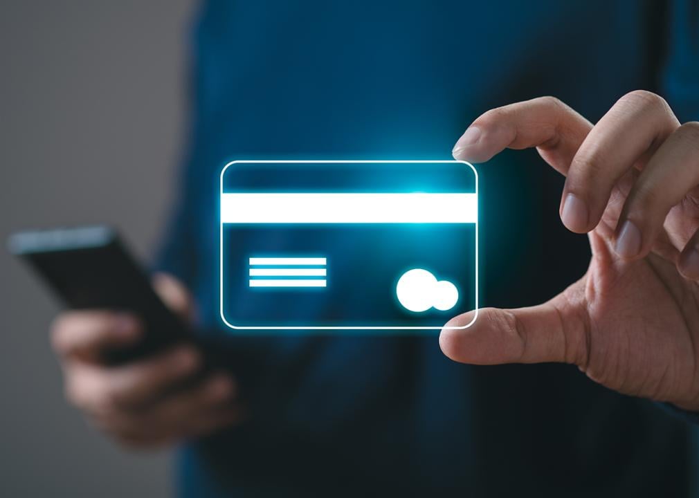 Person gesturing holding a credit card but it is illustrated holographically as a virtual item.